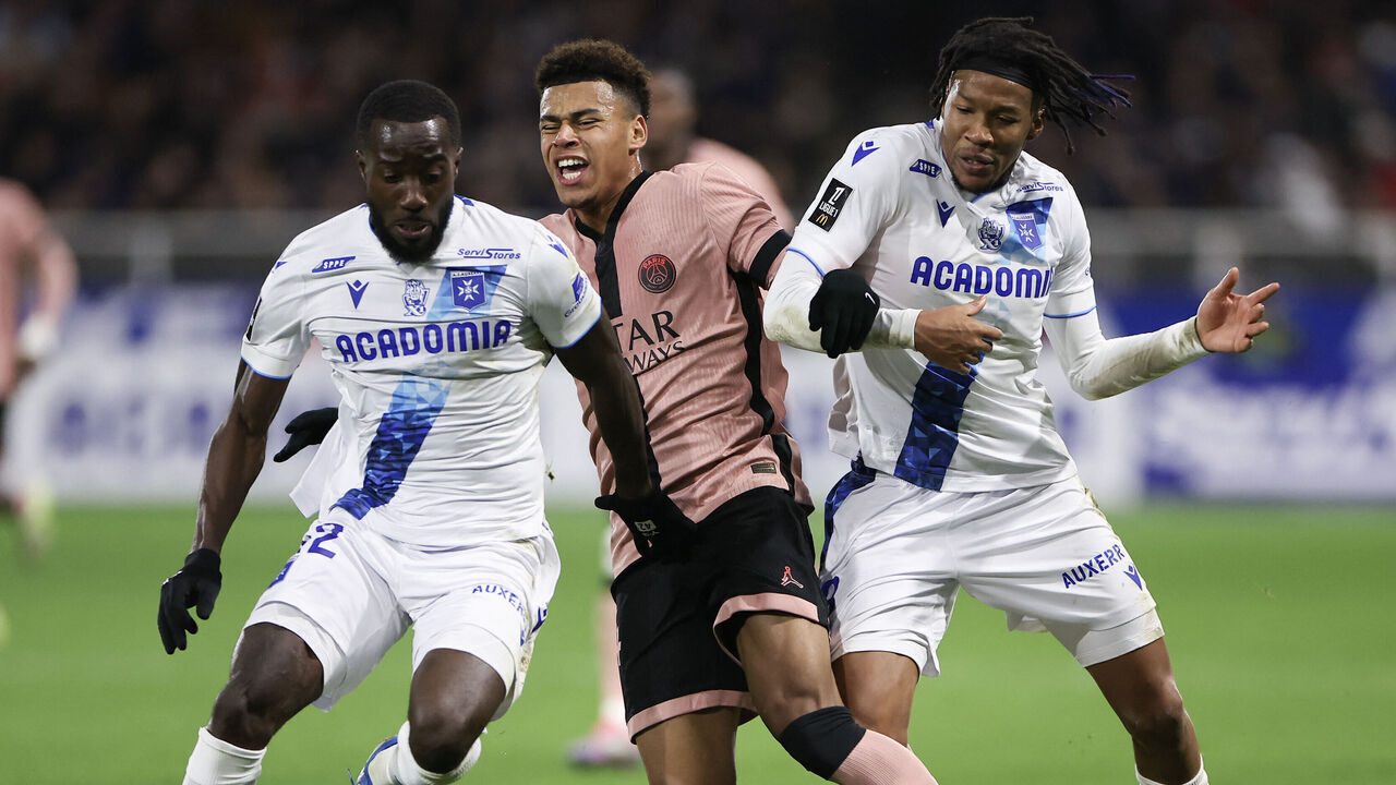 Auxerre's Ghanaian midfielder #42 Elisha Owusu (L), Paris Saint-Germain's French midfielder #14 Desire Doue (C) and Auxerre's Nigerian defender Gabriel Osho (R) fight for the ball during the French L1 football match between AJ Auxerre and Paris Saint-Germain (PSG) at Stade de l'Abbe-Deschamps in Auxerre, central France on December 6, 2024.