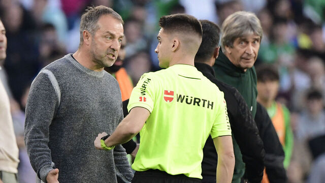 Barcelona's German coach Hans-Dieter Flick (L) reacts to receiving a red card during the Spanish league football match between Real Betis and FC Barcelona at the Benito Villamarin stadium in Seville on December 7, 2024.