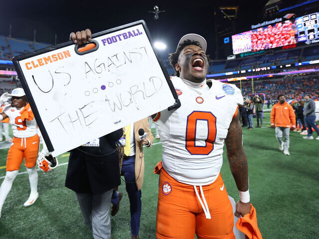 CHARLOTTE, NORTH CAROLINA - DECEMBER 07: Antonio Williams #0 holds an "Us Against The World" sign while celebrating with the Clemson Tigers after winning the 2024 ACC Football Championship at Bank of America Stadium on December 07, 2024 in Charlotte, North Carolina.
