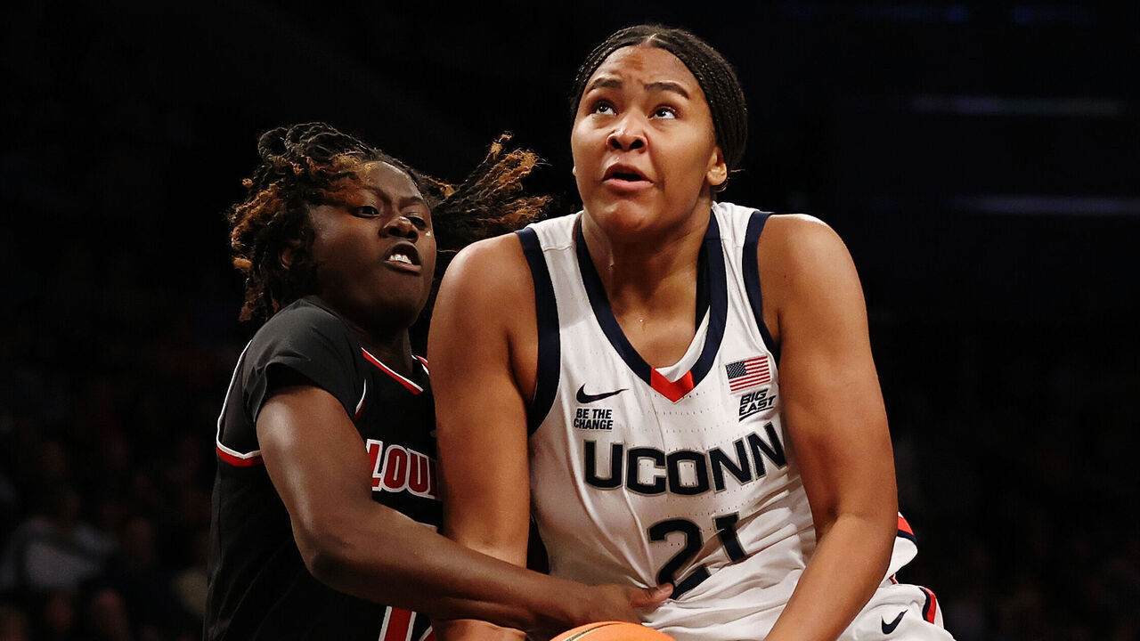 NEW YORK, NEW YORK - DECEMBER 07: Sarah Strong #21 of the UConn Huskies goes to the basket as Ja'Leah Williams #12 and Nyla Harris #2 of the Louisville Cardinals defend during the first half in the Shark Beauty Women's Champions Classic at Barclays Center on December 07, 2024 in the Brooklyn borough of New York City.