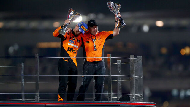 ABU DHABI, UNITED ARAB EMIRATES - DECEMBER 08: Race winner Lando Norris of Great Britain and McLaren and McLaren Chief Executive Officer Zak Brown celebrate on the podium after the McLaren team won the 2024 F1 Constructors Championship during the F1 Grand Prix of Abu Dhabi at Yas Marina Circuit on December 08, 2024 in Abu Dhabi, United Arab Emirates.