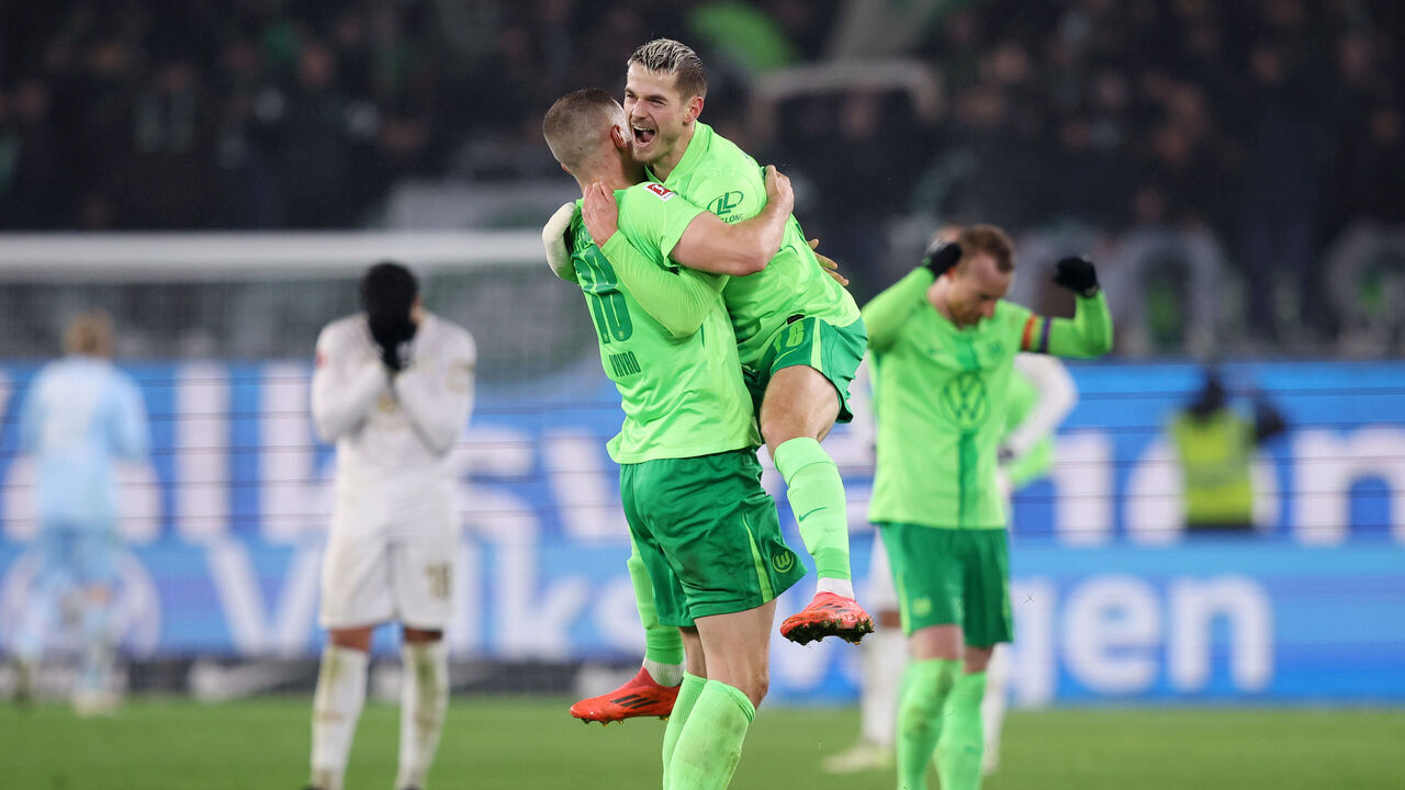 WOLFSBURG, GERMANY - DECEMBER 08: Denis Vavro and Jakub Kaminski of VfL Wolfsburg celebrate following the team's victory in the Bundesliga match between VfL Wolfsburg and 1. FSV Mainz 05 at Volkswagen Arena on December 08, 2024 in Wolfsburg, Germany.
