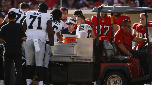 TAMPA, FLORIDA - DECEMBER 08: Aidan O'Connell #12 of the Las Vegas Raiders is assisted off the field by medical staff after an apparent injury during the third quarter against the Tampa Bay Buccaneers at Raymond James Stadium on December 08, 2024 in Tampa, Florida.
