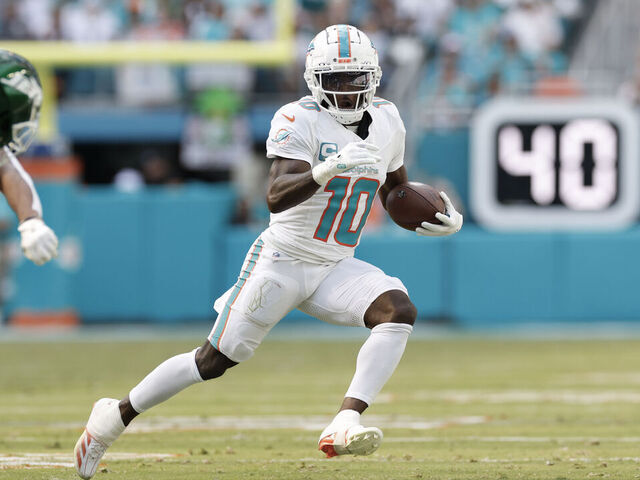MIAMI GARDENS, FL - DECEMBER 08: Miami Dolphins wide receiver Tyreek Hill (10) runs with the ball after a catch during the game between the Miami Dolphins and the New York Jets on December 8, 2024 at Hard Rock Stadium in Miami Gardens, Fl.