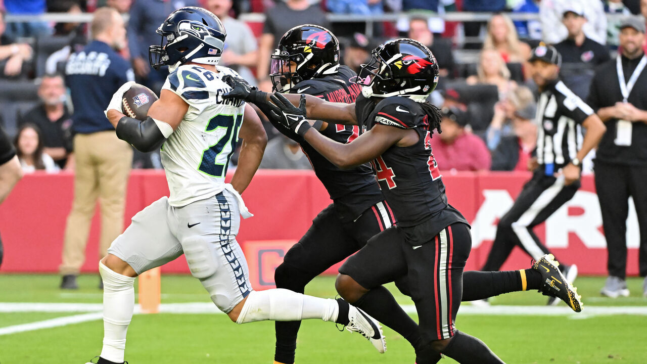 GLENDALE, ARIZONA - DECEMBER 08: Zach Charbonnet #26 of the Seattle Seahawks runs with the ball while being chased by Sean Murphy-Bunting #23 and Starling Thomas V #24 of the Arizona Cardinals in the second quarter at State Farm Stadium on December 08, 2024 in Glendale, Arizona.