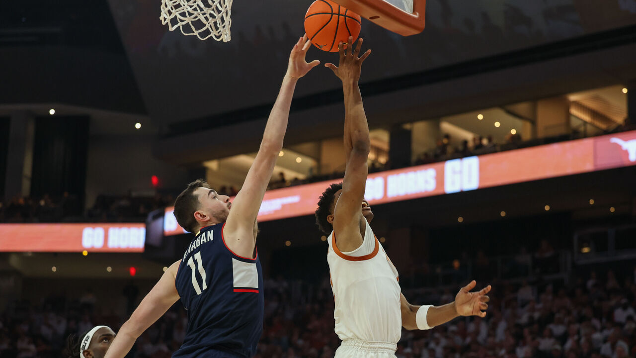 AUSTIN, TX - DECEMBER 08: Connecticut Huskies forward Alex Karaban (11) blocks a sho attempt by Texas Longhorns guard Julian Larry (1) during the college basketball game between Texas Longhorns and University of Connecticut Huskies on December 8, 2024, at Moody Center in Austin, Texas.