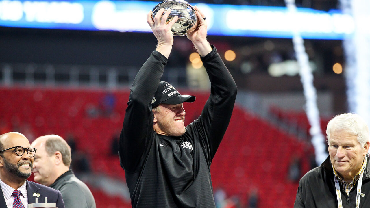 ATLANTA, GA - JANUARY 1: UCF Knights head coach Scott Frost holds up the trophy after the 2017 Chick-fil-A Peach Bowl football game between The University of Central Florida and the Auburn University on January, 1 2018 at Mercedes-Benz Stadium in Atlanta, GA. UCF wins 34-27.