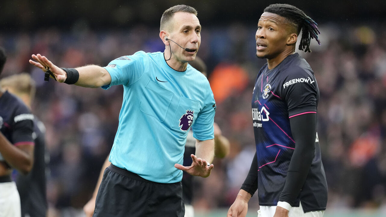 Match referee David Coote (left) speaks with Luton Town's Gabriel Osho during the Premier League match at Molineux Stadium, Wolverhampton. Picture date: Saturday April 27, 2024.