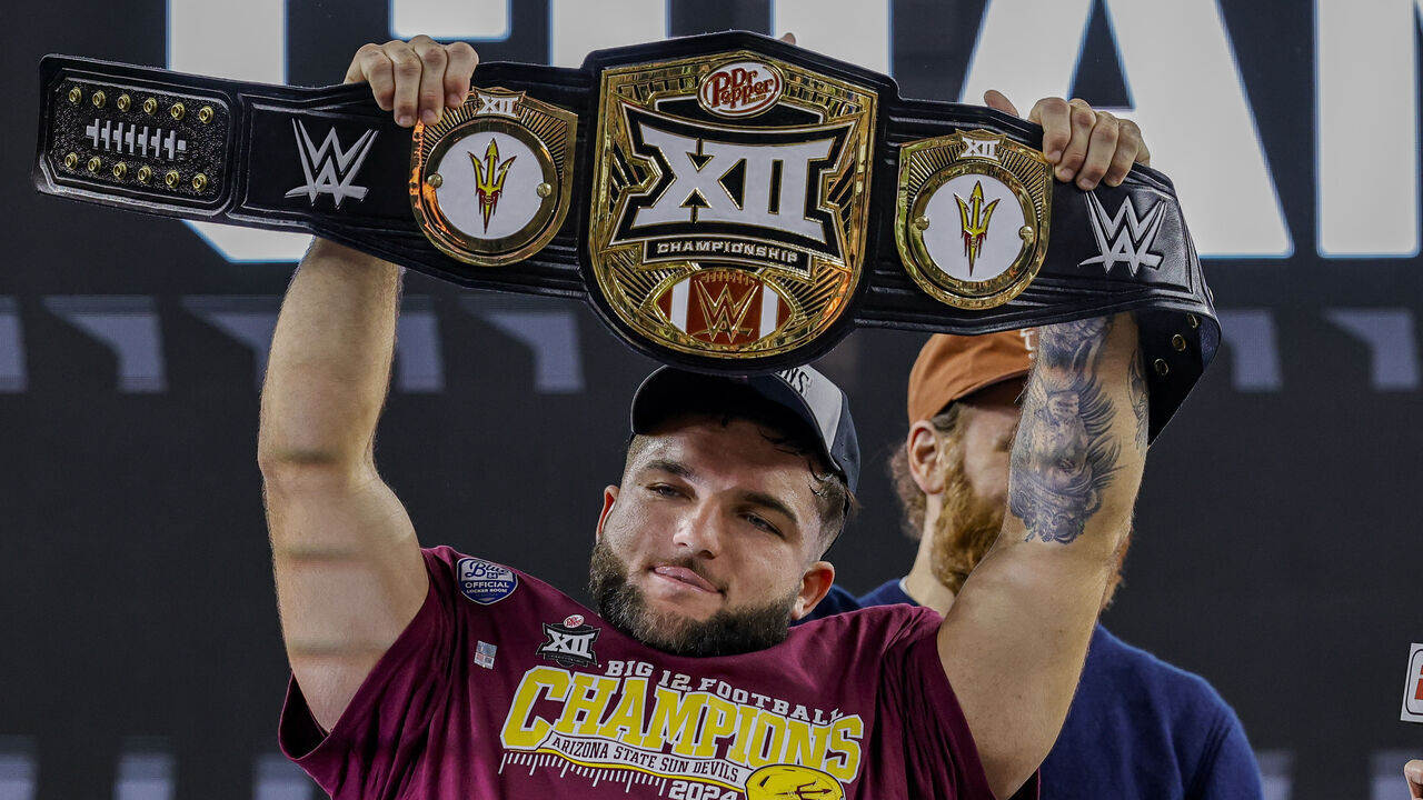 ARLINGTON, TX - DECEMBER 07: Arizona State Sun Devils running back Cam Skattebo (4) holds up the trophy belt after winning the Big 12 Championship game between the Arizona State Sun Devils and the Iowa State Cyclones on December 7, 2024 at AT&T Stadium in Arlington, Texas.