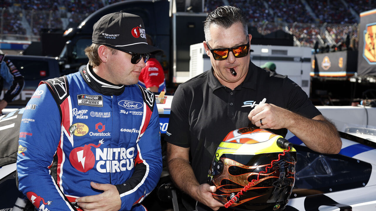 AVONDALE, ARIZONA - NOVEMBER 10: Stewart-Haas Racing co-owner, Tony Stewart (R) signs the helmet of Noah Gragson, driver of the #10 Nitro Circus Ford, on the grid prior to the NASCAR Cup Series Championship Race at Phoenix Raceway on November 10, 2024 in Avondale, Arizona.