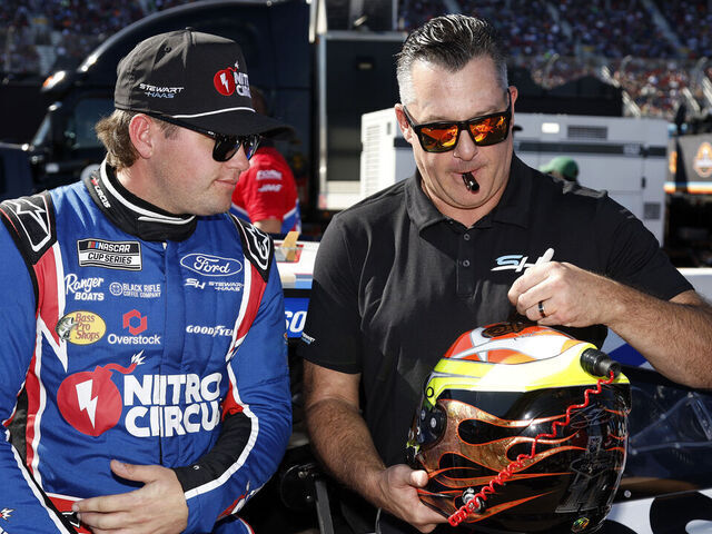 AVONDALE, ARIZONA - NOVEMBER 10: Stewart-Haas Racing co-owner, Tony Stewart (R) signs the helmet of Noah Gragson, driver of the #10 Nitro Circus Ford, on the grid prior to the NASCAR Cup Series Championship Race at Phoenix Raceway on November 10, 2024 in Avondale, Arizona.