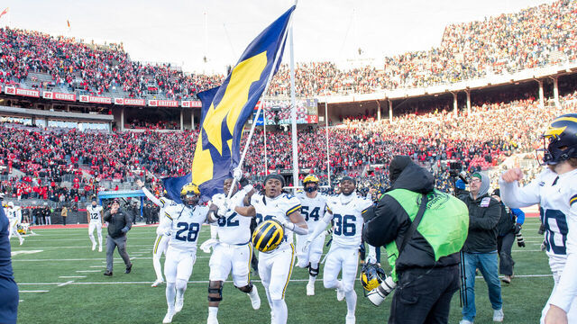 COLUMBUS, OHIO - NOVEMBER 30: Quinton Johnson #28, Raheem Anderson #62, Tavierre Dunlap #22, and Keshaun Harris #36 of the Michigan Wolverines run to plant the Michigan flag at center field after a college football game against the Ohio State Buckeyes at Ohio Stadium on November 30, 2024 in Columbus, OH. The Michigan Wolverines won the game 13-10.