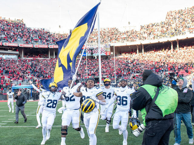 COLUMBUS, OHIO - NOVEMBER 30: Quinton Johnson #28, Raheem Anderson #62, Tavierre Dunlap #22, and Keshaun Harris #36 of the Michigan Wolverines run to plant the Michigan flag at center field after a college football game against the Ohio State Buckeyes at Ohio Stadium on November 30, 2024 in Columbus, OH. The Michigan Wolverines won the game 13-10.