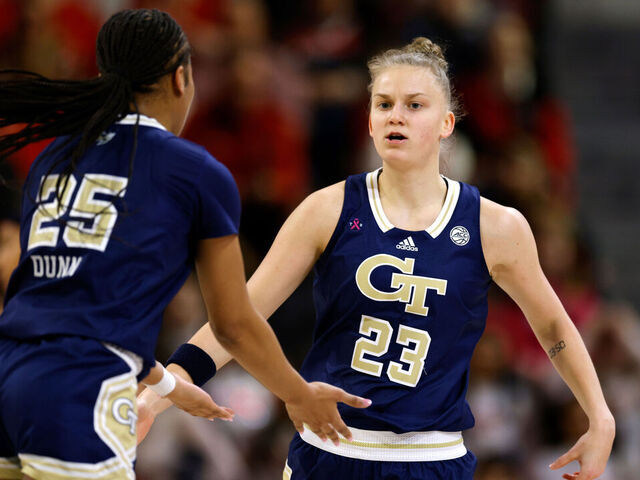 RALEIGH, NORTH CAROLINA - FEBRUARY 18: Rusne Augustinaite #23 of the Georgia Tech Yellow Jackets reacts following her basket with teammate Kara Dunn #25 during the first half of their game against the NC State Wolfpack at Reynolds Coliseum on February 18, 2024 in Raleigh, North Carolina.