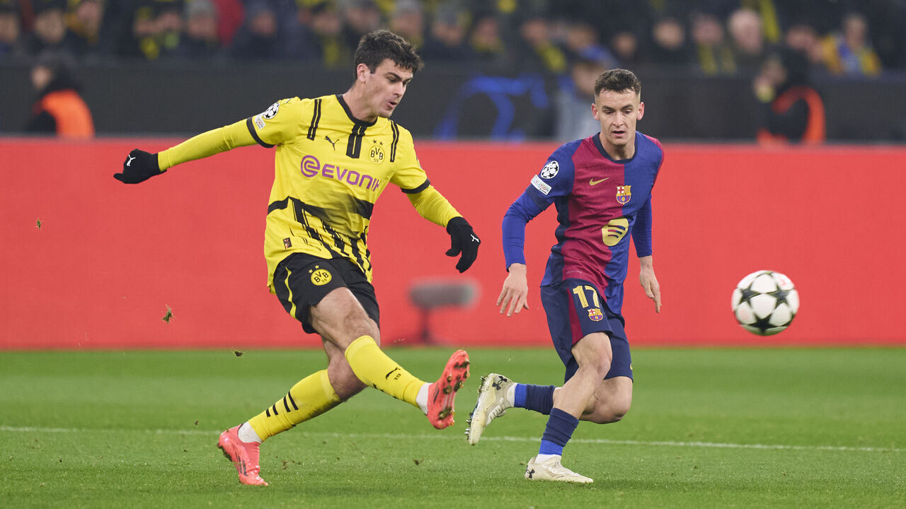 DORTMUND, GERMANY - DECEMBER 11: Giovanni Reyna of Borussia Dortmund kicks the ball next to Marc Casado of FC Barcelona during the UEFA Champions League 2024/25 League Phase MD6 match between Borussia Dortmund and FC Barcelona at Signal Iduna Park on December 11, 2024 in Dortmund, Germany.