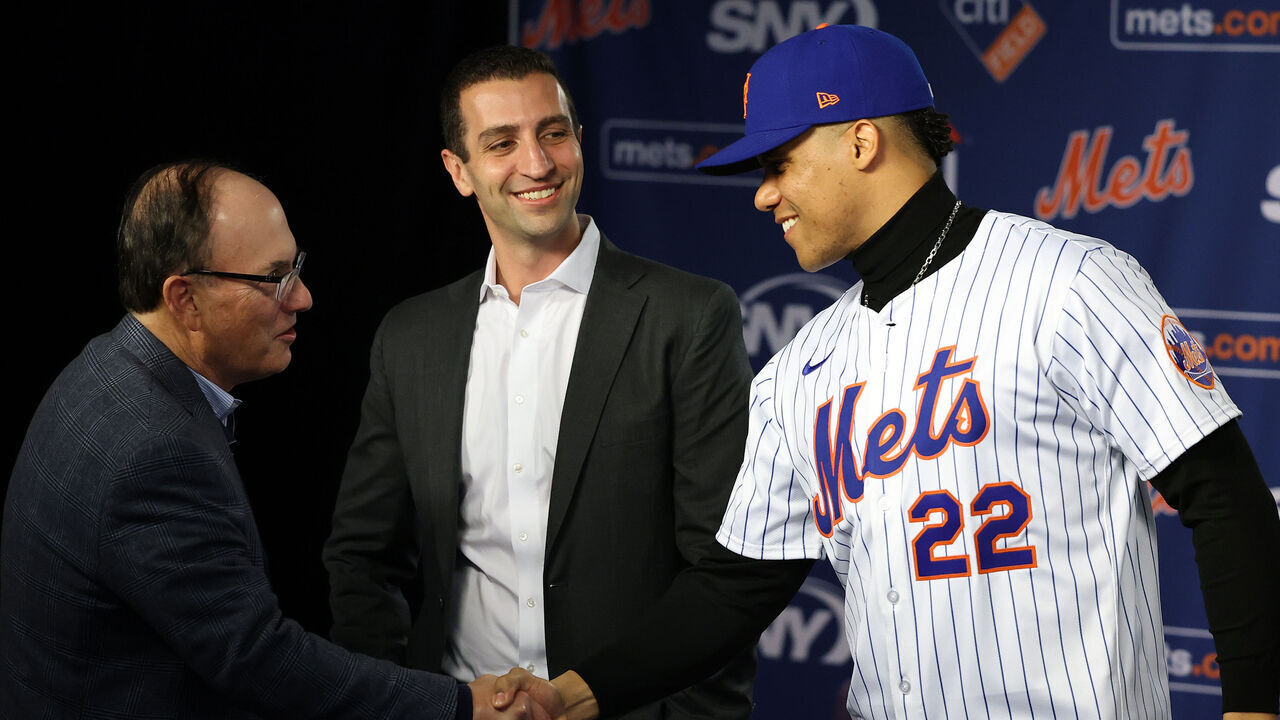 NEW YORK, NEW YORK - DECEMBER 12: Steve Cohen, Owner of the New York Mets shakes hands with Juan Soto as David Stearns, the president of baseball operations watches during his introductory press conference at Citi Field on December 12, 2024 in New York City.