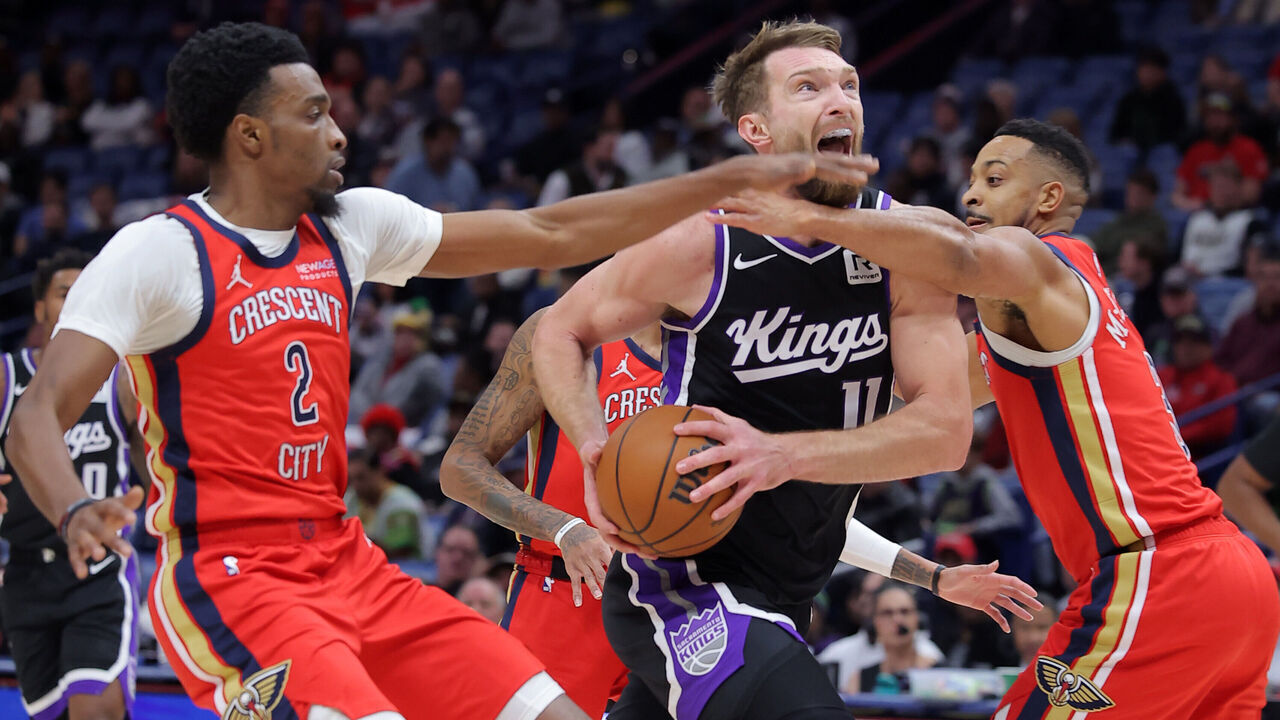NEW ORLEANS, LOUISIANA - DECEMBER 12: Domantas Sabonis #11 of the Sacramento Kings drives against Herbert Jones #2 and CJ McCollum #3 of the New Orleans Pelicans during the first half at the Smoothie King Center on December 12, 2024 in New Orleans, Louisiana.