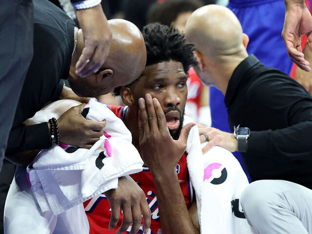 PHILADELPHIA, PENNSYLVANIA - DECEMBER 13: Trainers tend to Joel Embiid #21 of the Philadelphia 76ers during the first half against the Indiana Pacers at the Wells Fargo Center on December 13, 2024 in Philadelphia, Pennsylvania.