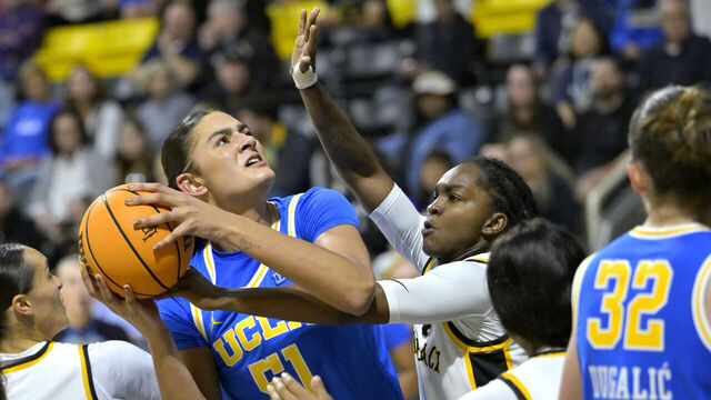 LONG BEACH, CALIFORNIA - DECEMBER 14: Lauren Betts #51 of the UCLA Bruins is defended by Lovely Sonnier #1 of the Long Beach State 49ers in the second half at Walter Pyramid on December 14, 2024 in Long Beach, California.