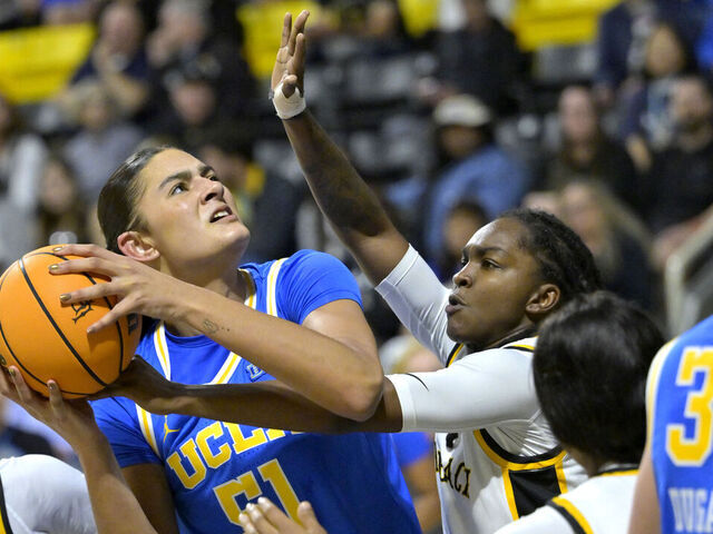 LONG BEACH, CALIFORNIA - DECEMBER 14: Lauren Betts #51 of the UCLA Bruins is defended by Lovely Sonnier #1 of the Long Beach State 49ers in the second half at Walter Pyramid on December 14, 2024 in Long Beach, California.