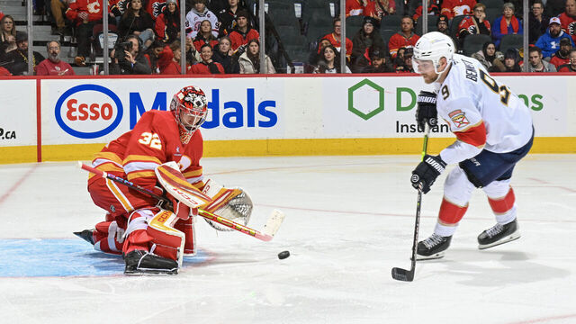 CALGARY, ALBERTA - DECEMBER 14: Dustin Wolf #32 of the Calgary Flames makes a save against Sam Bennett #9 of the Florida Panthers at the Scotiabank Saddledome on December 14, 2024 in Calgary, Alberta.