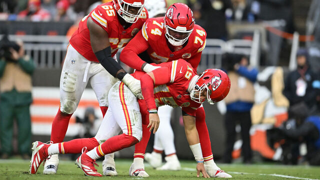 CLEVELAND, OHIO - DECEMBER 15: Trey Smith #65 and Jawaan Taylor #74 of the Kansas City Chiefs help up quarterback Patrick Mahomes #15 after a hit during the third quarter against the Cleveland Browns at Huntington Bank Field on December 15, 2024 in Cleveland, Ohio.