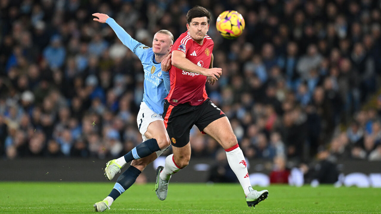 MANCHESTER, ENGLAND - DECEMBER 15: Erling Haaland of Manchester City in action alongside Harry Maguire of Manchester United during the Premier League match between Manchester City FC and Manchester United FC at Etihad Stadium on December 15, 2024 in Manchester, England.