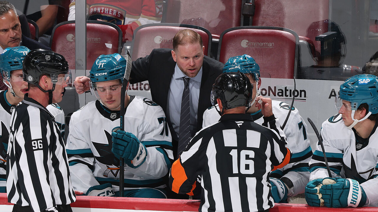 SUNRISE, FL - DECEMBER 7: Referee Brian Pochmara #16 explains a tripping penalty to head coach Ryan Warsofsky of the San Jose Sharksduring second period action against the Florida Panthers at the Amerant Bank Arena on December 7, 2024 in Sunrise, Florida.