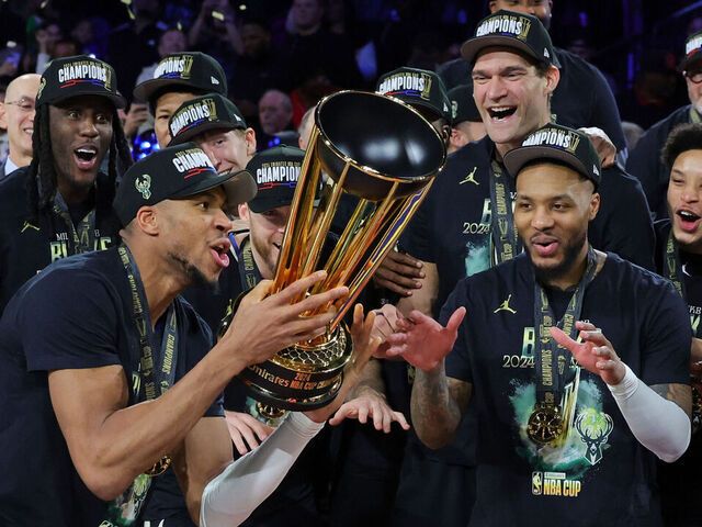 LAS VEGAS, NEVADA - DECEMBER 17: Giannis Antetokounmpo (L) #34 of the Milwaukee Bucks lifts the championship trophy as he celebrates with teammates, including Damian Lillard (R) #0, after the Bucks defeated the Oklahoma City Thunder 97-81 to win the championship game of the Emirates NBA Cup at T-Mobile Arena on December 17, 2024 in Las Vegas, Nevada.