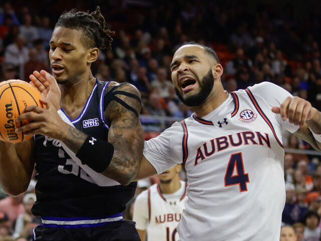 AUBURN, ALABAMA - DECEMBER 17: Johni Broome #4 of the Auburn Tigers is injured going for a rebound against Nick McMullen during the first half at Neville Arena on December 17, 2024 in Auburn, Alabama.