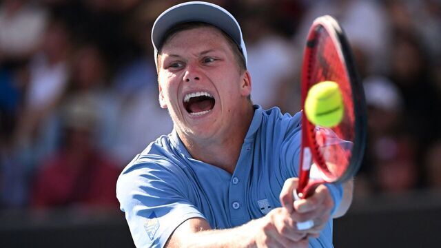 TOPSHOT - USA's Jenson Brooksby hits a return against USA's Tommy Paul during their men's singles match on day six of the Australian Open tennis tournament in Melbourne on January 21, 2023. - -- IMAGE RESTRICTED TO EDITORIAL USE - STRICTLY NO COMMERCIAL USE --