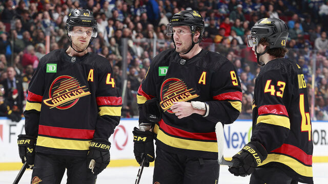 VANCOUVER, CANADA - APRIL 10: J.T. Miller #9 of the Vancouver Canucks talks to teammates Quinn Hughes #43 and Elias Pettersson #40 during their NHL game against the Arizona Coyotes at Rogers Arena on April 10, 2024 in Vancouver, British Columbia, Canada.