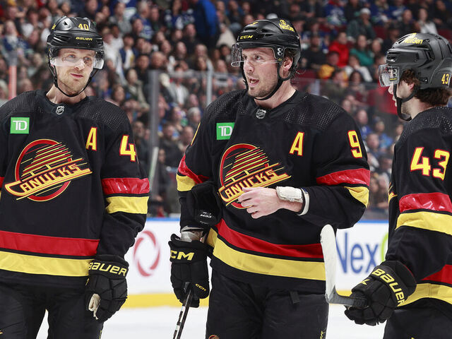 VANCOUVER, CANADA - APRIL 10: J.T. Miller #9 of the Vancouver Canucks talks to teammates Quinn Hughes #43 and Elias Pettersson #40 during their NHL game against the Arizona Coyotes at Rogers Arena on April 10, 2024 in Vancouver, British Columbia, Canada.