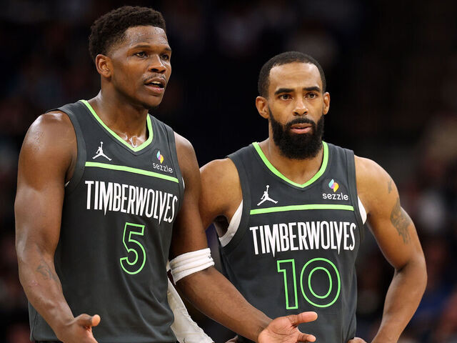 MINNEAPOLIS, MINNESOTA - DECEMBER 21: Anthony Edwards #5 of the Minnesota Timberwolves interacts with teammate Mike Conley #10 in the fourth quarter against the Golden State Warriors at Target Center on December 21, 2024 in Minneapolis, Minnesota. The Warriors defeated the Timberwolves 113-103.