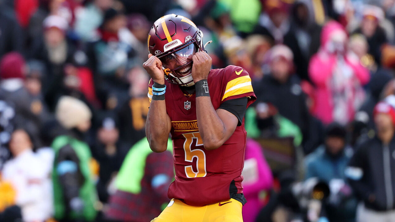 LANDOVER, MARYLAND - DECEMBER 22: Jayden Daniels #5 of the Washington Commanders celebrates after throwing a touchdown pass against the Philadelphia Eagles during the second quarter at Northwest Stadium on December 22, 2024 in Landover, Maryland.