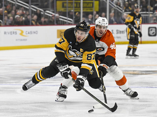 PITTSBURGH, PA - DECEMBER 23: Pittsburgh Penguins center Sidney Crosby (87) skates with the puck against Philadelphia Flyers center Morgan Frost (48) during the first period in the NHL game between the Pittsburgh Penguins and the Philadelphia Flyers on December 23, 2024, at PPG Paints Arena in Pittsburgh, PA.