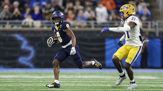 DETROIT, MICHIGAN - DECEMBER 26: Jacquez Stuart #0 of the Toledo Rockets runs the ball up the field against Rasheem Biles #31 of the Pittsburgh Panthers in the first quarter of the GameAbove Sports Bowl game at Ford Field on December 26, 2024 in Detroit, Michigan.
