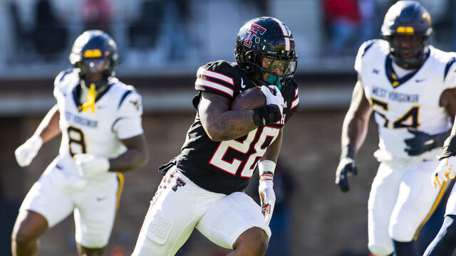 LUBBOCK, TEXAS - NOVEMBER 30: Tahj Brooks #28 of the Texas Tech Red Raiders runs the ball during the first half of the game against the West Virginia Mountaineers at Jones AT&T Stadium on November 30, 2024 in Lubbock, Texas.