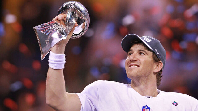 Indianapolis, IN � New York Giants quarterback Eli Manning is reflected as he holds up the Lombardi trophy after beating the New England Patriots, again, in SuperBowl XLVI at Lucas Oil Stadium on Sunday, February 5, 2012. Staff Photo by Matthew West.