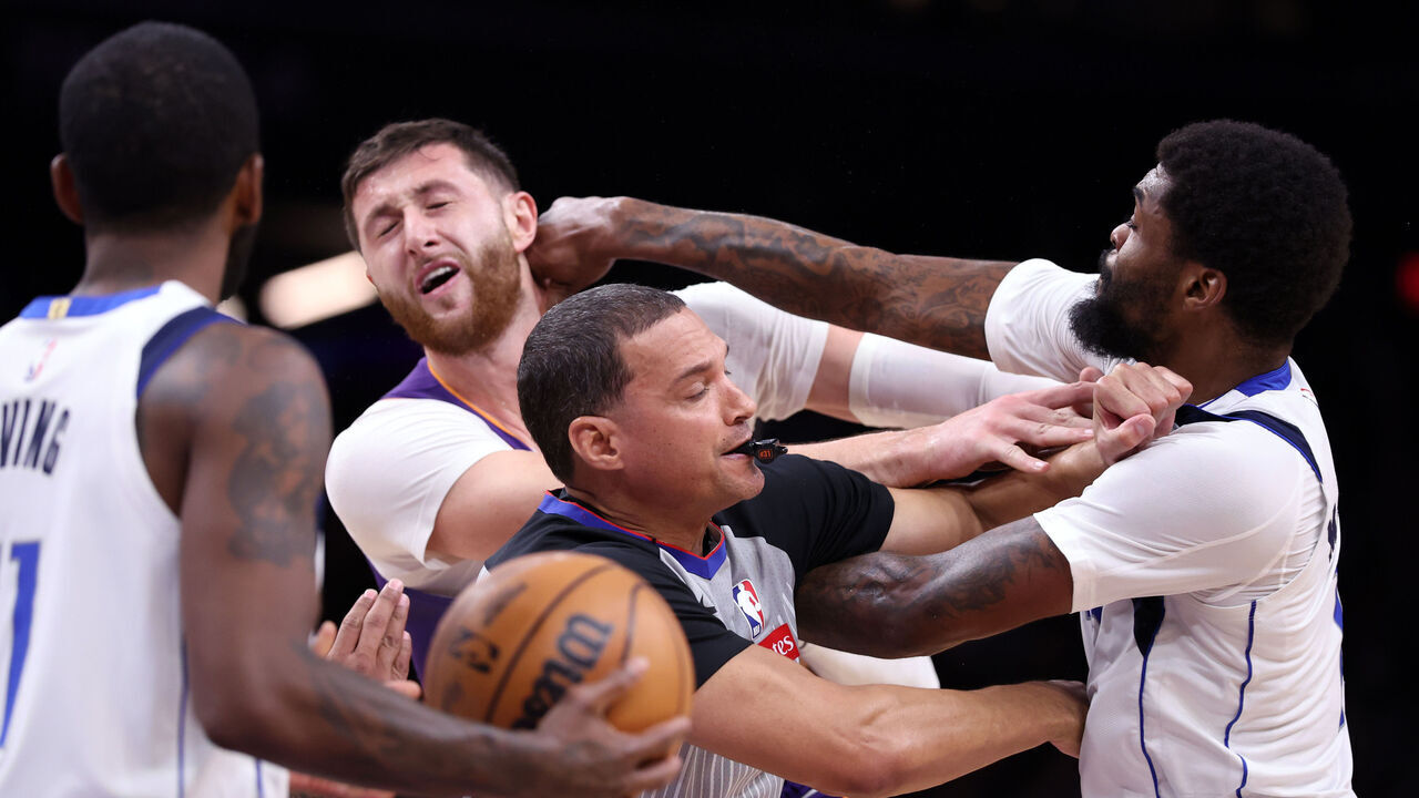PHOENIX, ARIZONA - DECEMBER 27: Naji Marshall #13 of the Dallas Mavericks punches Jusuf Nurkic #20 of the Phoenix Suns during the second half at Footprint Center on December 27, 2024 in Phoenix, Arizona.