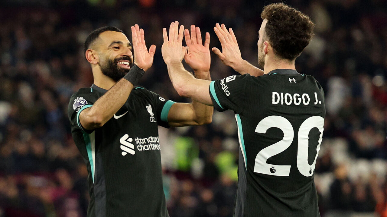 Liverpool's Portuguese striker #20 Diogo Jota celebrates scoring the team's fifth goal with Liverpool's Egyptian striker #11 Mohamed Salah during the English Premier League football match between West Ham United and Liverpool at the London Stadium, in London on December 29, 2024.