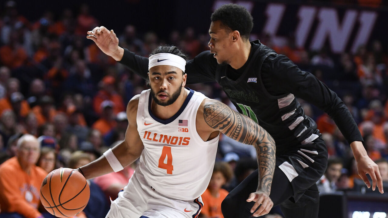CHAMPAIGN, IL - DECEMBER 29: Illinois Fighting Illini Guard Kylan Boswell (4) works the ball inside against Chicago State Cougars Forward Noble Crawford (11) during the college basketball game between the Chicago State Cougars and the Illinois Fighting Illini on December 29, 2024, at the State Farm Center in Champaign, Illinois.