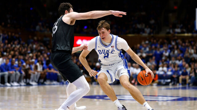DURHAM, NORTH CAROLINA - DECEMBER 31: Cooper Flagg #2 of the Duke Blue Devils moves the ball against Ben Burnham #13 of the Virginia Tech Hokies during the first half of the game at Cameron Indoor Stadium on December 31, 2024 in Durham, North Carolina.