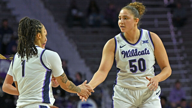 MANHATTAN, KS - DECEMBER 18: Ayoka Lee #50 of the Kansas State Wildcats gets a hand from teammate Zyanna Walker #1 after a play in the first half against the New Mexico State Aggies at Bramlage Coliseum on December 18, 2024 in Manhattan, Kansas.