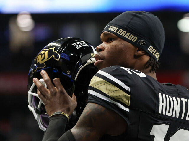 SAN ANTONIO, TX - DECEMBER 28: Colorado Buffaloes wide receiver Travis Hunter (12) readies to put his helmet on before the football game between BYU Cougars and Colorado Buffalos on December 28, 2024, at the Alamodome in San Antonio, Texas.