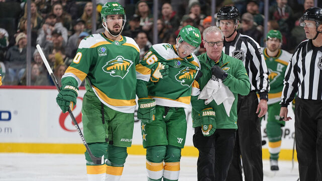 SAINT PAUL, MN - DECEMBER 31: Jared Spurgeon #46 is assisted by his teammate Marcus Johansson #90 of the Minnesota Wild and a member of the training staff during the game against the Nashville Predators at the Xcel Energy Center on December 31, 2024 in Saint Paul, Minnesota.
