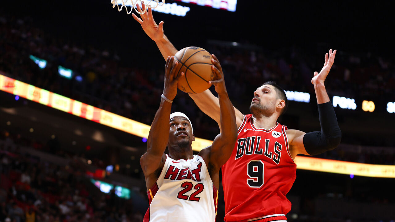 MIAMI, FLORIDA - DECEMBER 14: Jimmy Butler #22 of the Miami Heat drives against Nikola Vucevic #9 of the Chicago Bulls during the second quarter of the game at Kaseya Center on December 14, 2023 in Miami, Florida.