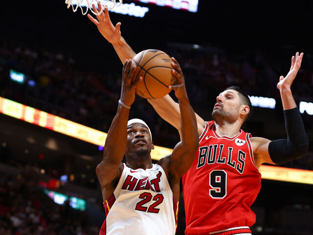 MIAMI, FLORIDA - DECEMBER 14: Jimmy Butler #22 of the Miami Heat drives against Nikola Vucevic #9 of the Chicago Bulls during the second quarter of the game at Kaseya Center on December 14, 2023 in Miami, Florida.