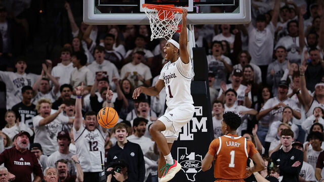COLLEGE STATION, TEXAS - JANUARY 04: Zhuric Phelps #1 of the Texas A&M Aggies celebrates after dunking the ball over Julian Larry #1 of the Texas Longhorns during the second half at Reed Arena on January 04, 2025 in College Station, Texas.