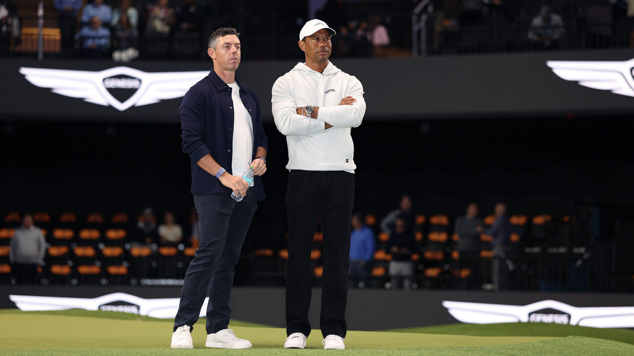 PALM BEACH GARDENS, FLORIDA - JANUARY 07: Rory McIlroy of Boston Common Golf and Tiger Woods of Jupiter Links Golf Club look on before the TGL presented by SoFi match between the New York Golf Club and The Bay Golf Club at SoFi Center on January 07, 2025 in Palm Beach Gardens, Florida.
